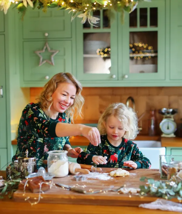 mom and daughter baking cookies during holidays