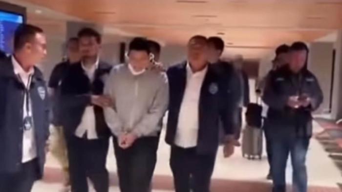 RESBOB DI BANDARA SOETTA - Streamer Resbob saat digiring aparat Polda Jawa Barat di Bandara Internasional Soekarno-Hatta, Senin (15/12/2025). Resbob ditangkap karena menghina suku Sunda dalam streamingnya.