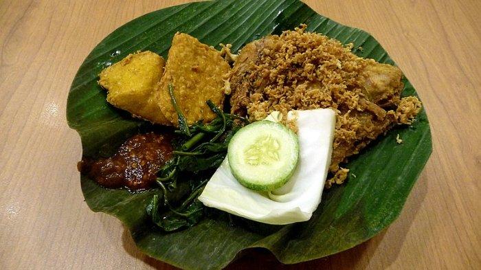 Ilustrasi ayam penyet dengan sambal dan lalapan.