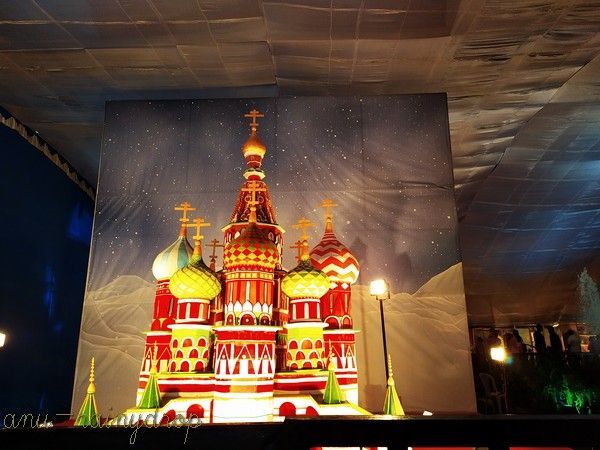 This may contain: an image of a church lit up in red, white and yellow with christmas lights