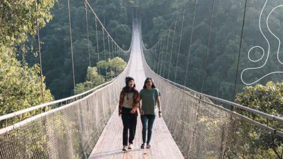 WISATA SUKABUMI - Pengunjung tengah melintasi Jembatan Gantung Situ Gunung yang ikonik di Sukabumi, Jawa Barat, Rabu (17/12/2025).