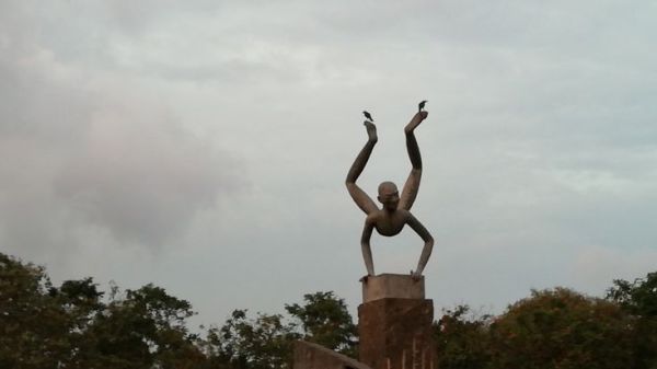 This may contain: there is a statue that has birds on it's back and arms in the air