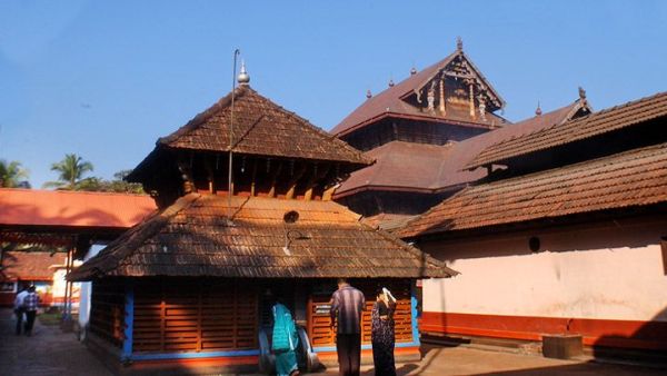 This may contain: two men standing in front of an old building with wooden roofing and tall towers