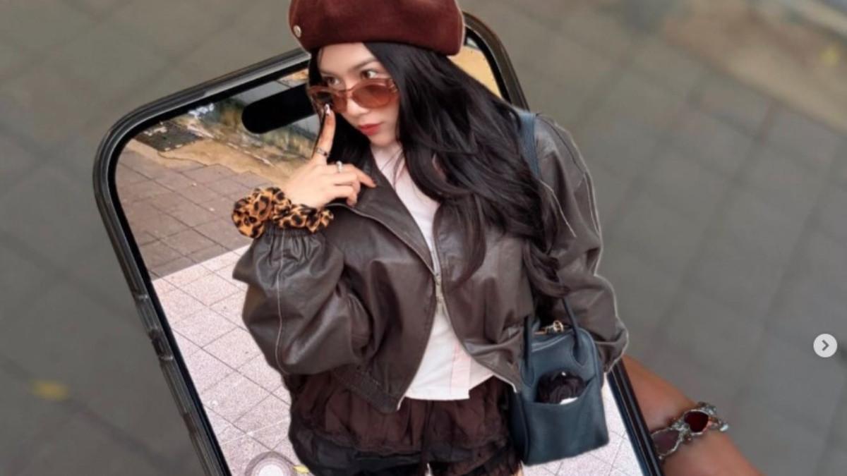 Saat berada di Korea, Diva Azzura tampil mencolok dengan padu padan kemeja pink pastel, jaket kulit dan celana pendek hitam.