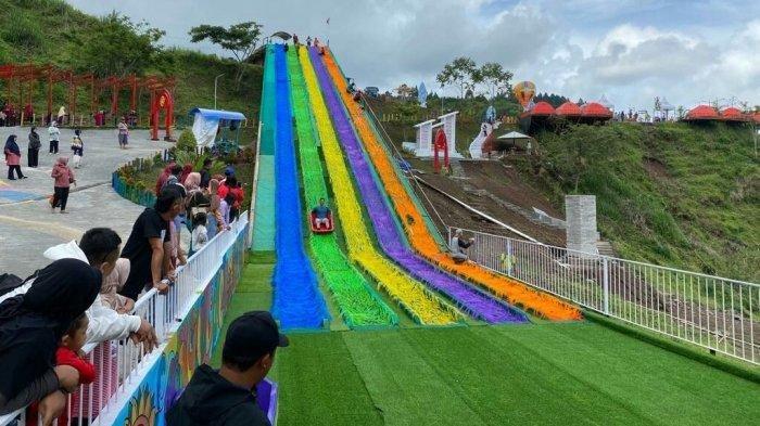 PEROSOTAN PELANGI - Suasana di wahana perosotan pelangi atau rainbow slide di Golden Park, salah satu destinasi wisata baru di DTW Guci, Kabupaten Tegal, Sabtu (8/10/2022). Terlihat pengunjung sedang meluncur di salah satu perosotan yang memiliki panjang sampai 74 meter dan tinggi 12 meter.