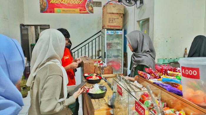 KULINER BOGOR - Suasana sebelum seblak diolah. Pelanggan menyerahkan topping yang sudah dipilih kepada staf untuk dimasak.