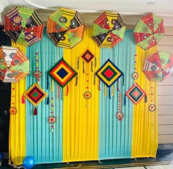 This may contain: colorful decorations are hanging on the side of a wall with blue and yellow drapes