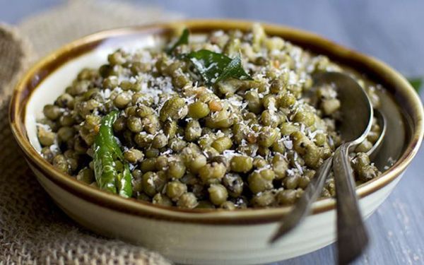 This may contain: a bowl filled with green lentils on top of a table
