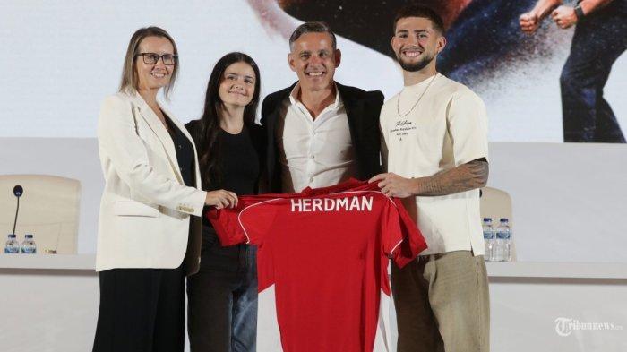 Pelatih Timnas Indonesia John Herdman bersama keluarganya menunjukkan jersey Timnas Indonesia saat acara perkenalan Pelatih Baru Timnas Indonesia di Jakarta, Selasa (13/1/2026).