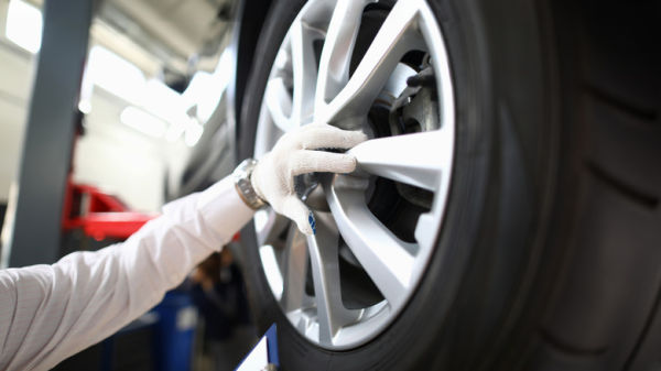 Auto pro inspecting the wheel of a car