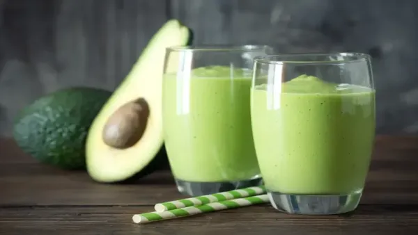 two glasses of Avacado smoothie and avacado on side