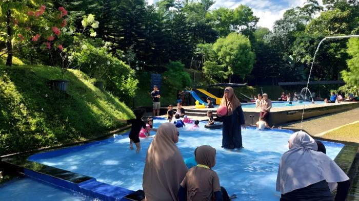 WISATA BOGOR - Anak-anak dan keluarga menikmati kesegaran air murni alami di kolam Boncahe bersumber dari mata air pegunungan sehingga aman dari kaporit.