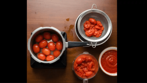 Fresh tomatoes are washed and boiled in a pressure cooker with water, then cooled and blended into a smooth tomato puree.