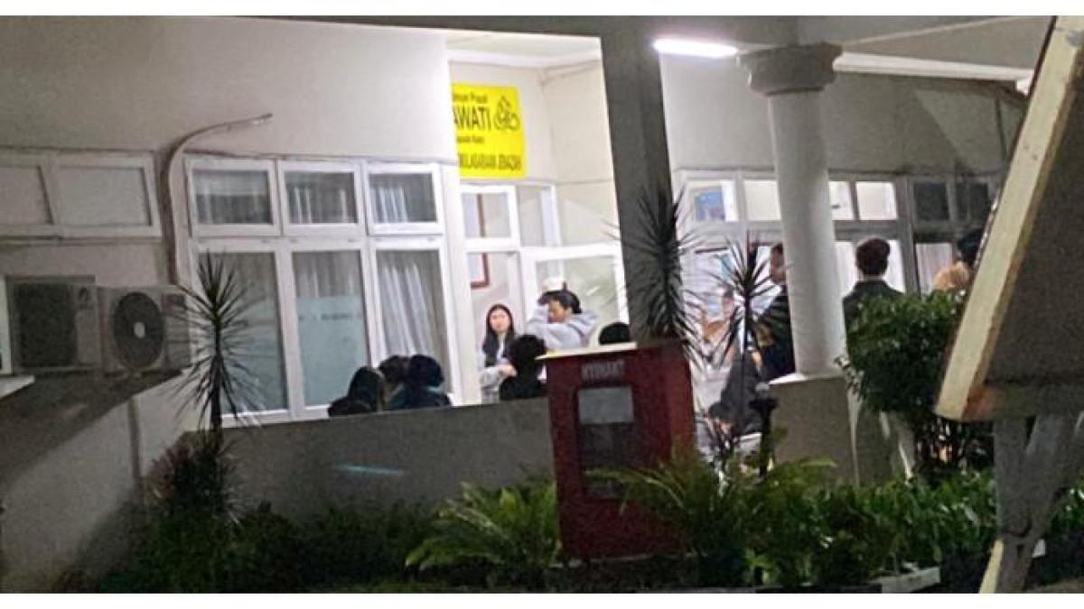 LULA LAHFAH MENINGGAL - Suasana rumah duka RSUP Fatmawati, Jakarta Selatan, tempat disemayamkannya jenazah Lula Lahfah, Jumat (23/1/2026). Terlihat dari kejauhan Reza Arap kekasih dari Lula Lahfah menggunakan hoodie atau jaket abu-abu dan topi bersandar di depan pintu masuk.