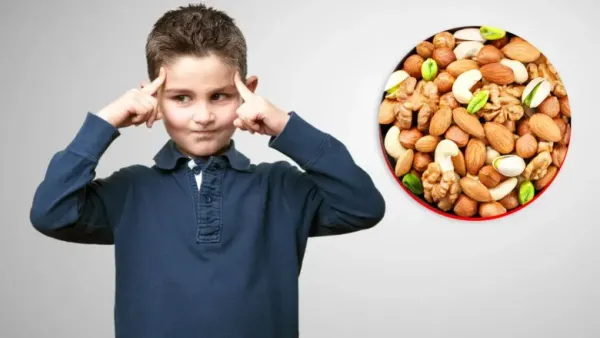 a boy shows thinking manner beside a bowl of dryfruits