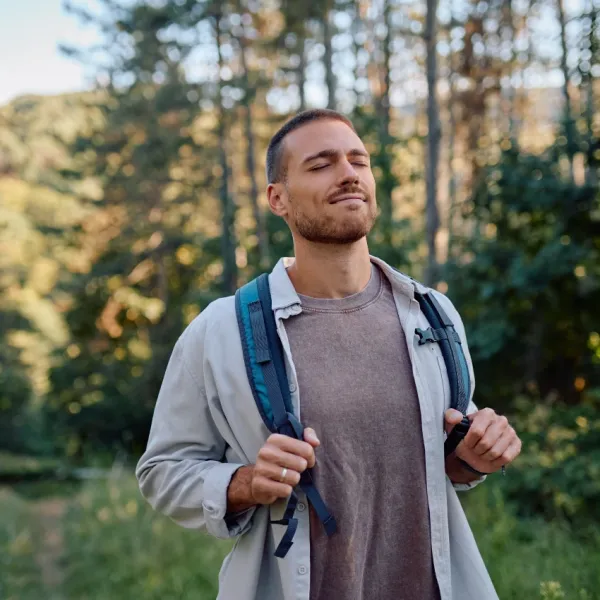 man listening birds walking in nature peaceful reduce stress