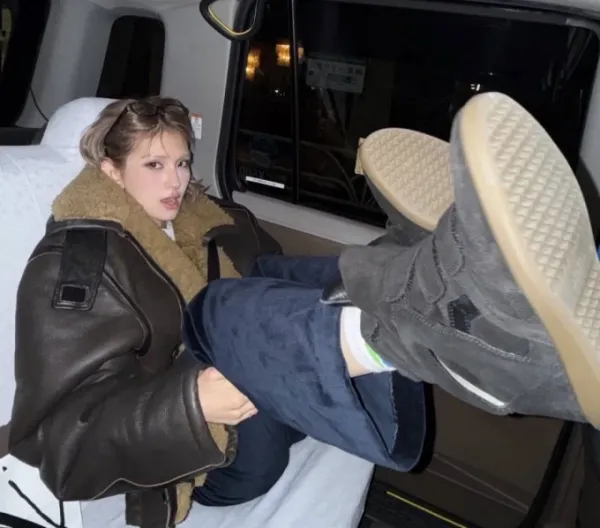 K-pop singer Jeon Somi poses for a photo in a taxi in Japan with her leg appearing raised toward the front seat. Photo retrieved from Jeons Instagram