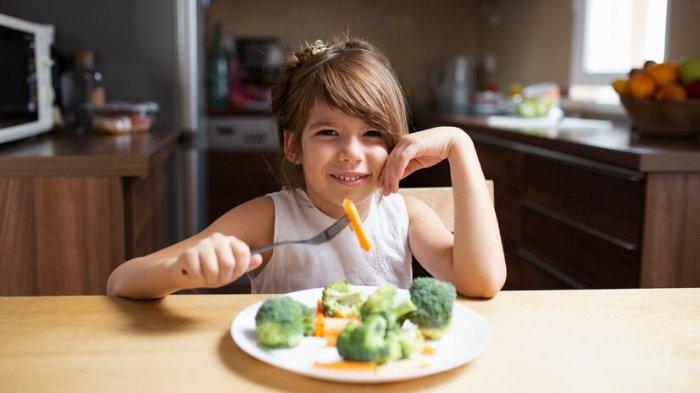 Ilustrasi anak yang mengonsumsi makanan bergizi, berikut penjelasan dokter spesialis gizi mengenai gizi seimbang pada anak