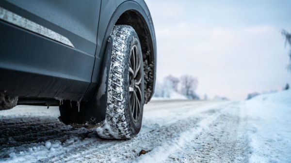 Close-up of a car tire on a snowy road in winter