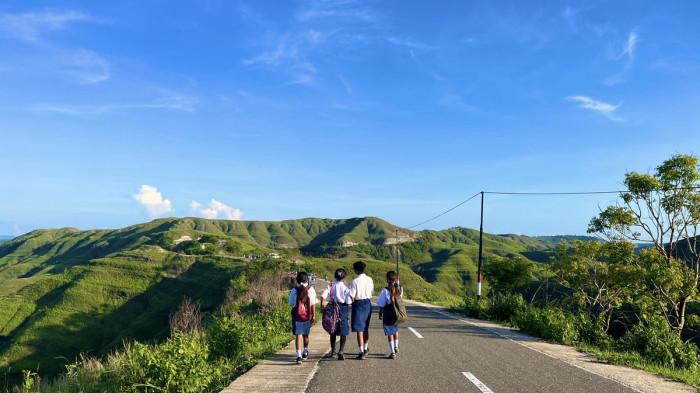 Para siswa sekolah di jalanan terindah Bukit Tanarara, Suma, Nusa Tenggara Timur, Rabu (26/11/2025).