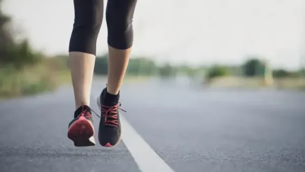 woman walking on road wearing shoes