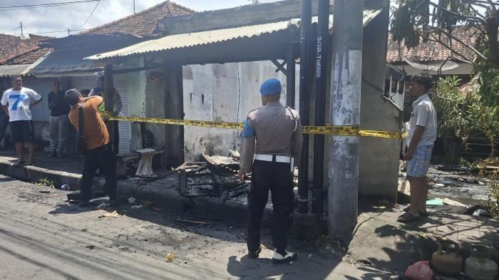 GARIS POLISI - Anggota Polsek Sawan saat memasang garis polisi di TKP pasca kebakaran yang terjadi di warung nasi Rasmini, di Banjar Dinas Peken, Desa Sangsit, Kecamatan Sawan, Buleleng, Rabu (18/2).