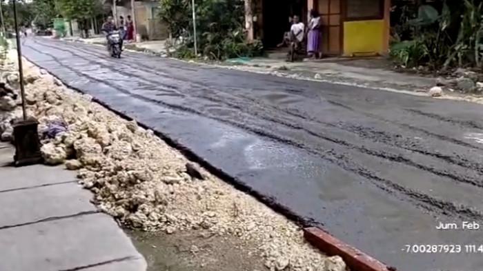 LINTASI JALAN COR - Warga Palon, Agus Sutrisno, saat melintasi jalan cor yang kondisinya masih basah, Jumat (20/2/2026). (Tangkapan Layar)