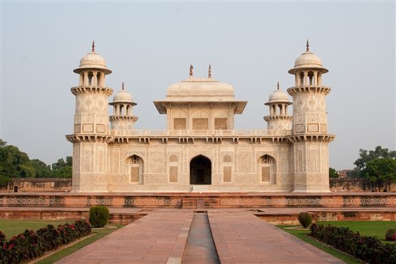 This may contain: a large white building with two towers on top of it's sides in the middle of a park