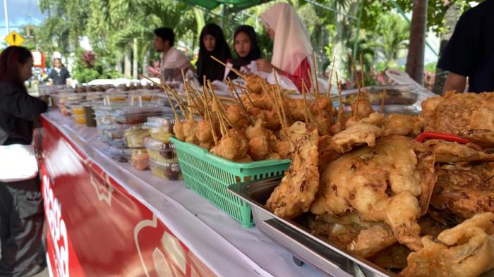 BERBURU TAKJIL - Potret warga berburu takjil di Jalan Piere Tendean Kota Manado, Sulut pada Kamis (26/2/2026) sore. Lapak-lapak pedagang berjajar di tepi jalan dengan tenda berwarna yang membentang memayungi area jualan.