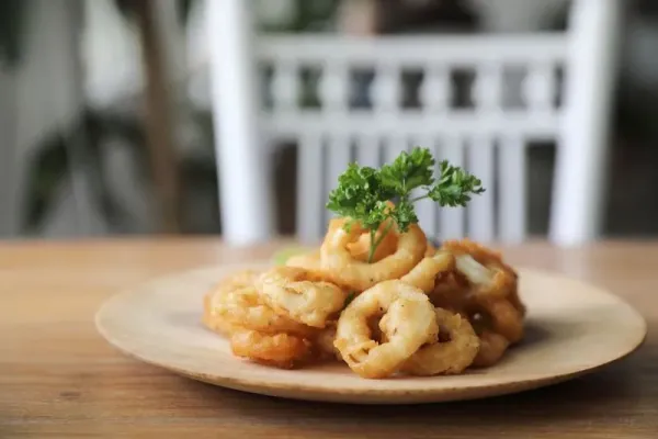 Caramari , Appetizer Crispy fried squid ring with tartar sauce on wood background traditional italian food