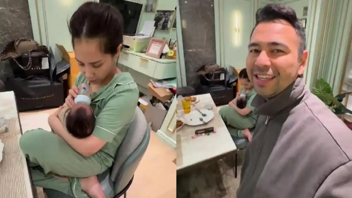 Nagita Slavina tampak duduk di ruang makan sambil menggendong bayi laki-laki yang sedang menyusu.