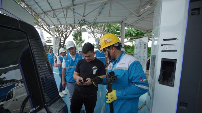 Petugas SPKLU membantu pelanggan melakukan pengisian daya listrik di SPKLU