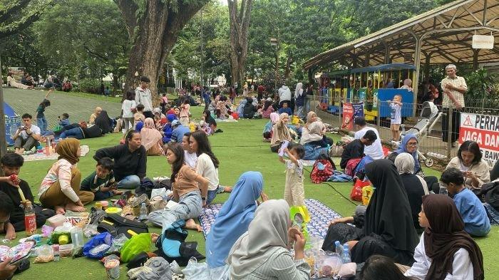BERCENGKERAMA - Wisatawan duduk-duduk sambil bercengkerama dengan keluarga saat berada di Taman Lalu Lintas, Bandung, Rabu (2/4/2025).