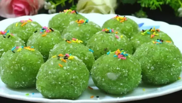 हिरवे लौकी लाडू वर चांदीचे वरक लावलेले, लाकडी पाटीवर ठेवलेले, एक कट उघडून आत भरलेले दाखवते.