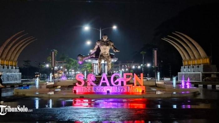 WISATA MALAM DI SRAGEN - Potret air mancur warna-warni di pintu masuk Kantor Terpadu Pemda Sragen pada saat malam hari, ada warga yang datang untuk melihat dan berfoto meski tengah hujan, Jumat (2/1/2026).