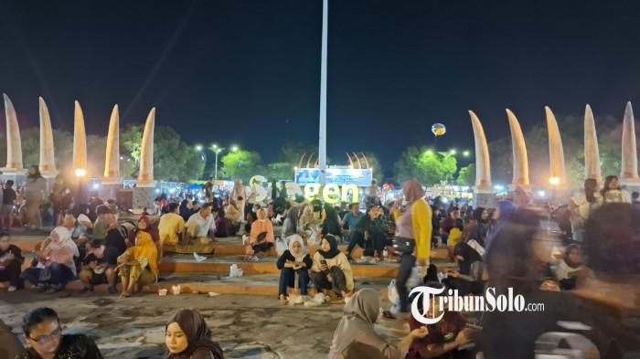 RAMAI WARGA - Warga Sragen tetap padati Alun-alun Sasono Langen Putro meski tak digelar panggung hiburan dan pesta kembang api di malam pergantian tahun baru 2026, Rabu (31/12/2025).