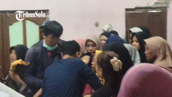 PINGSAN - Ibu Faiz Khairul Nizam (8) pingsan di tengah kerumunan pelayat di Dukuh Tasgunting, Desa Nangsri, Kecamatan Kebakkramat, Kabupaten Karanganyar, Selasa (31/3/2026). Sang putra ditemukan meninggal dunia usai sempat hilang di DAM Colo, Kebakkramat, Karanganyar sejak Minggu (29/3/2026). 