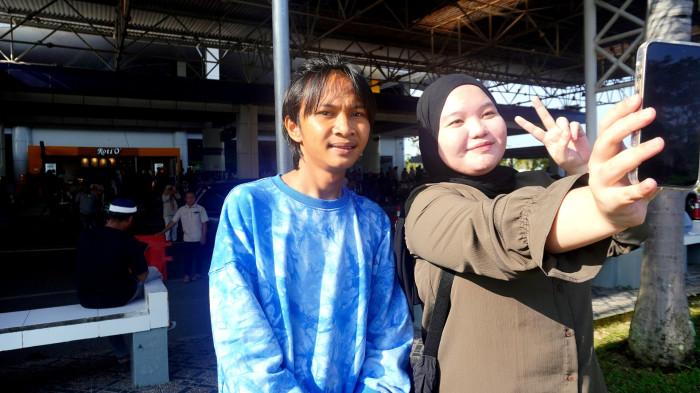FAJAR SADBOY — Seorang remaja perempuan berswafoto dengan Fajar Labatjo alias Fajar Sadboy di Bandara Djalaluddin Gorontalo, Sabtu (14/3/2026). Fajar pulang kampung ke Suwawa. (Sumber: TribunGorontalo.com/Fajri A Kidjab)