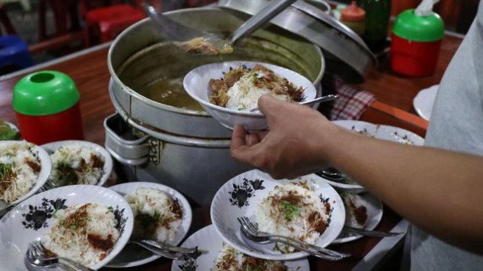 Penyajian rawon dan soto yang disiram kuah kaldu panas yang sudah bercampur rempah, di Rawon Kalkulator, Surabaya.