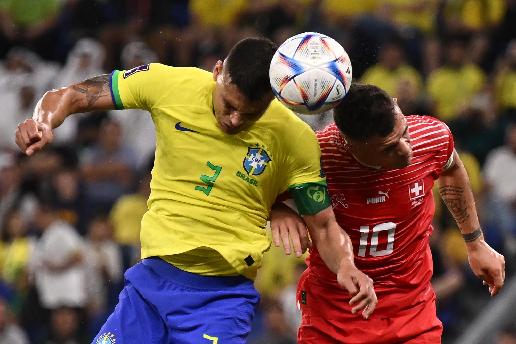 Bek Brasil Thiago Silva (Kiri) dan gelandang Swiss Granit Xhaka melompat untuk merebut bola selama pertandingan sepak bola Grup G Piala Dunia Qatar 2022 antara Brasil dan Swiss di Stadion 974 di Doha. Senin (28 November 2022). (Fabrice COFFRINI / AFP)