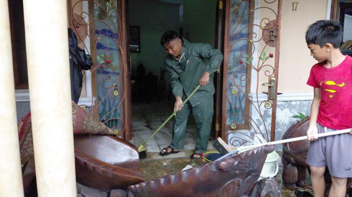 BANJIR DI PURWOKERTO - Suasana membersihkan rumah dari sisa banjir yang paling parah dialami oleh rumah milik Eliana Nurul Hidayah (63) di Perumahan Puri Intan, Kelurahan Pabuwaran, Kecamatan Purwokerto Utara, Selasa (14/4/2026). Rumah korban diketahui bersebelahan dengan proyek milik swasta yang sistem drainasenya tidak mampu menahan banjir dan menjebol tembok milik Eliana.