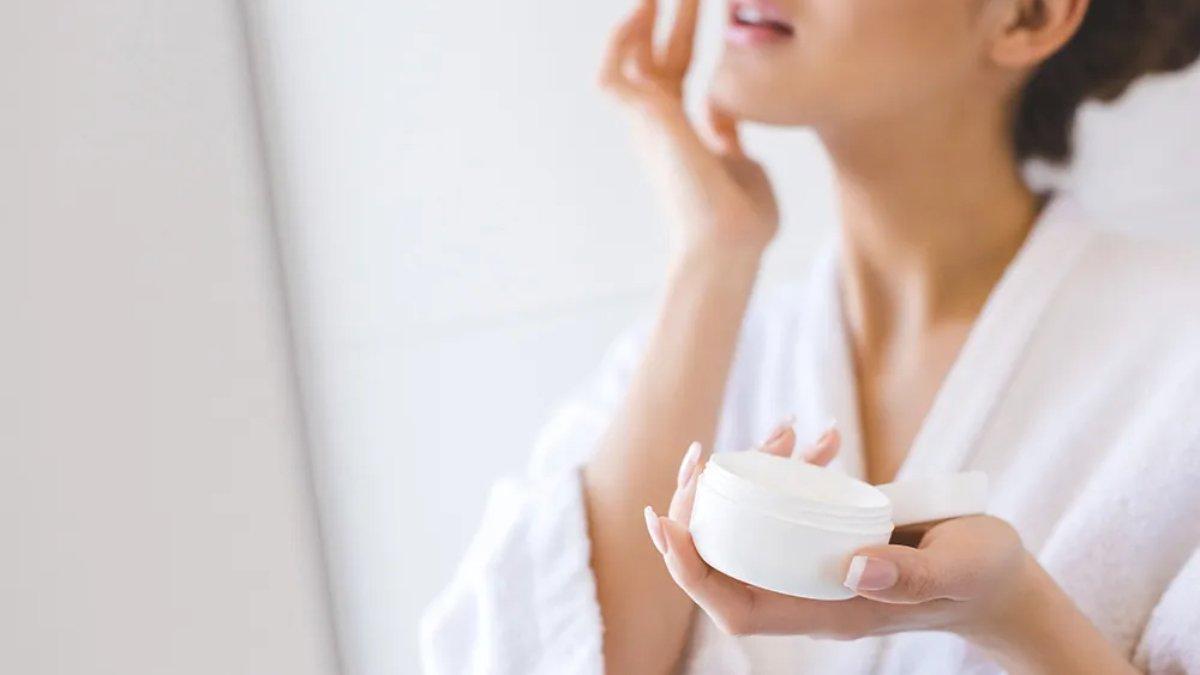 Ilustrasi wanita menggunakan serum dengan kandungan vitamin E