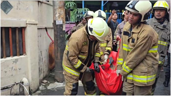 Petugas Sudin Gulkarmat Jakarta Barat mengevakuasi korban kebakaran di rumah kawasan Grogol