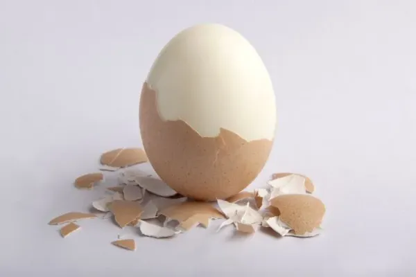 Mengupas telur rebus