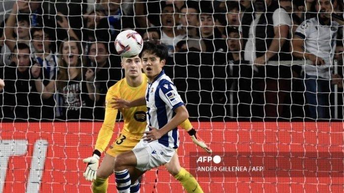 PENYERANG REAL SOCIEDAD-Kiper Barcelona asal Spanyol #13 Inaki Pena (kiri) menjaga gawang dari penyerang Real Sociedad asal Jepang #14 Takefusa Kubo selama pertandingan sepak bola liga Spanyol antara Real Sociedad dan FC Barcelona di stadion Anoeta di San Sebastian pada 10 November 2024. (ANDER GILLENEA/AFP)