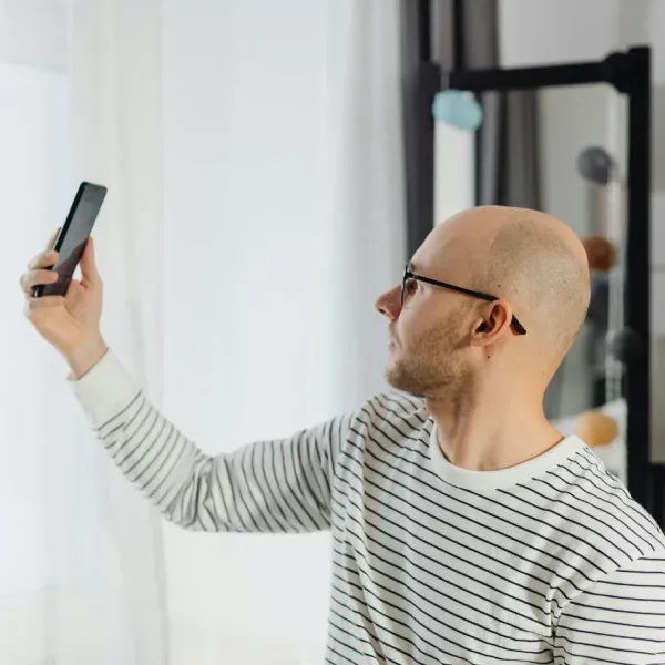 man taking picture to share on bald reddit