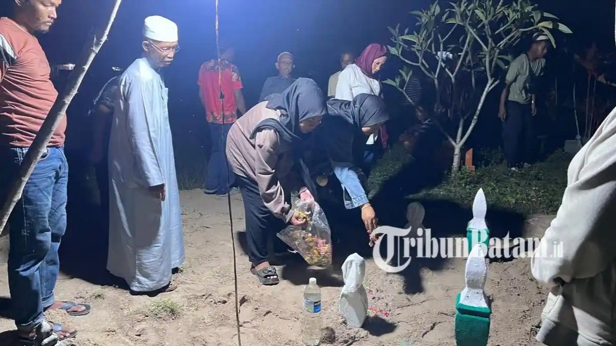 TABUR BUNGA - Sahabat Syafitri Yana saat menaburkan bunga usai jenazah dimakamkan di TPU Telek Singkep, Kabupaten Lingga, Provinsi Kepri, Kamis (30/4/2026) malam.