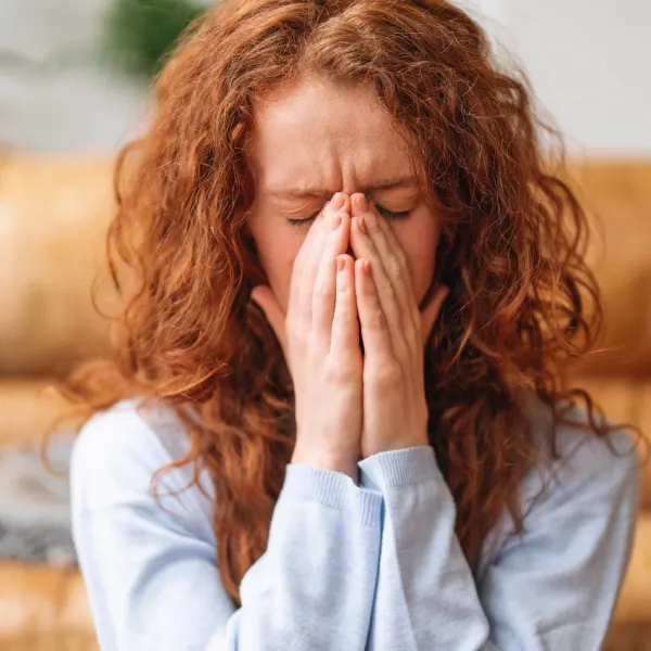 woman in emotional distress with hands over mouth