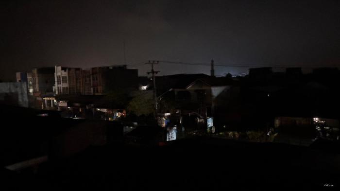 PEMADAMAN SERENTAK- Suasana gelap menyelimuti kawasan di Kota Medan saat pemadaman listrik serentak terjadi sejak pukul 18.45 WIB. Gangguan yang disebut meluas hingga wilayah Sumatera Bagian Utara (Sumbagut) membuat aktivitas masyarakat terganggu dan warga masih menunggu informasi resmi terkait penyebab serta waktu normalisasi listrik.