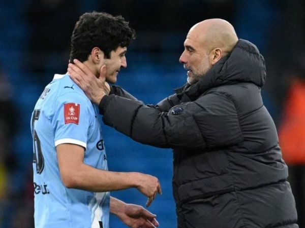 Pep Guardiola berbicara dengan bek Man City asal Uzbekistan, Abdukodir Khusanov, dalam laga melawan Salford City di Piala FA (14/2/2026).
